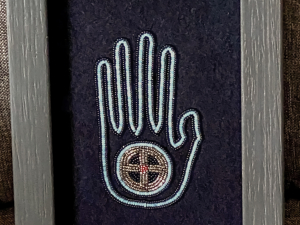 Framed two-point needle appliqué beadwork on wool